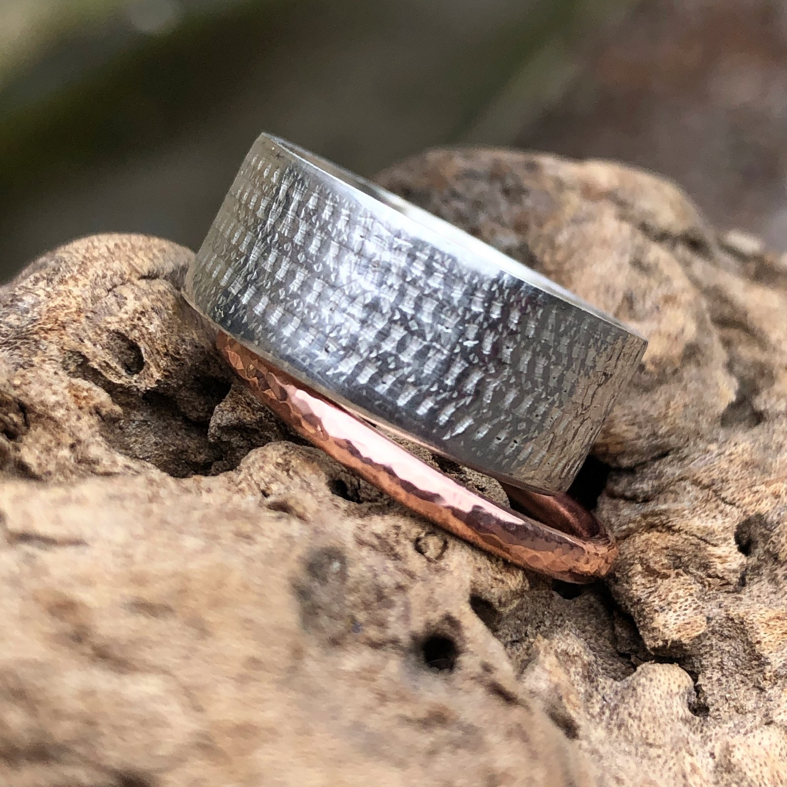 Wide silver ring with textured surface and hammered copper ring