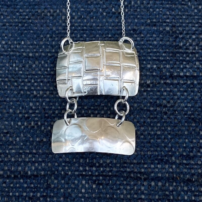 Silver pendant with textured surface and dangle