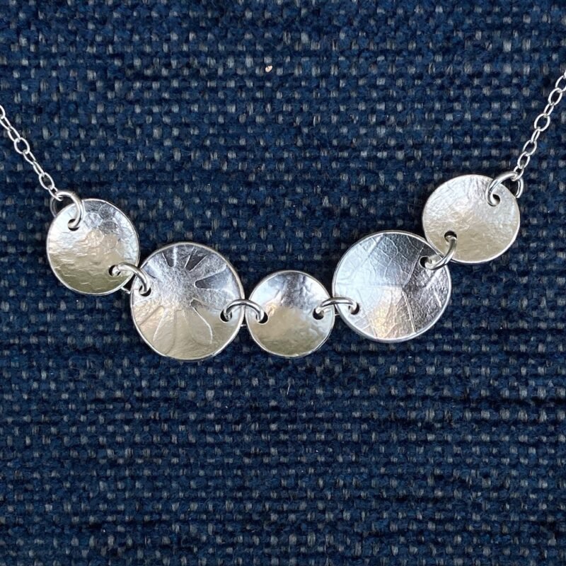 Silver necklace with textured discs linked with jump rings