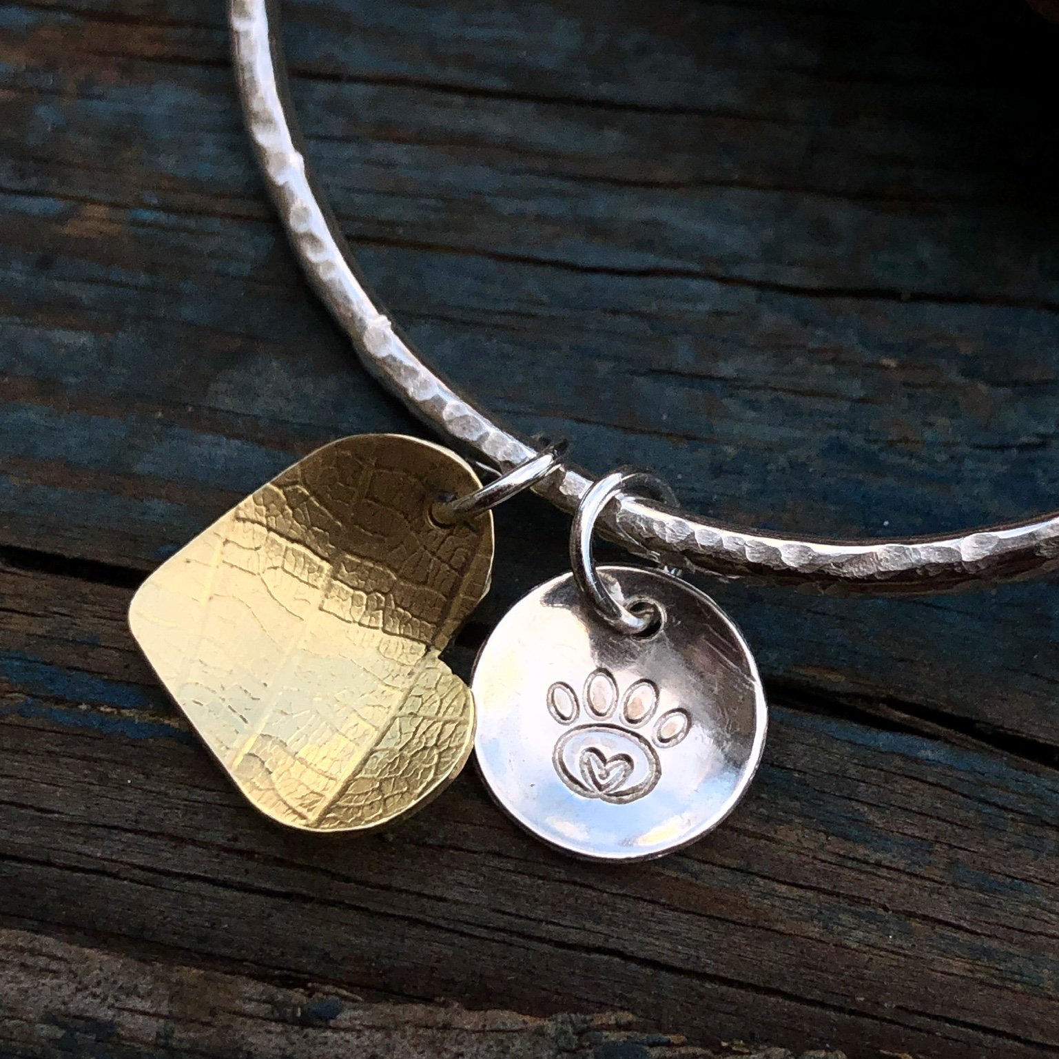Silver bangle with silver and brass charms