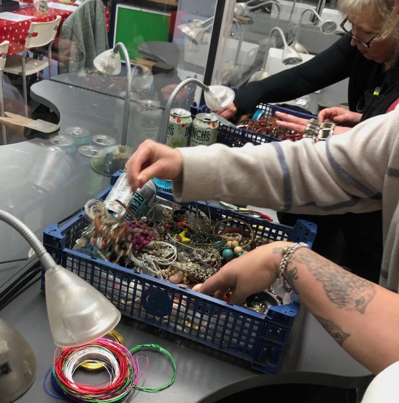Hands rummaging through junk and broken jewellery