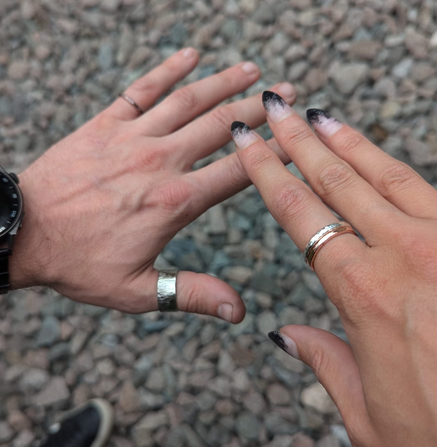 hands wearing silver rings made in the workshop