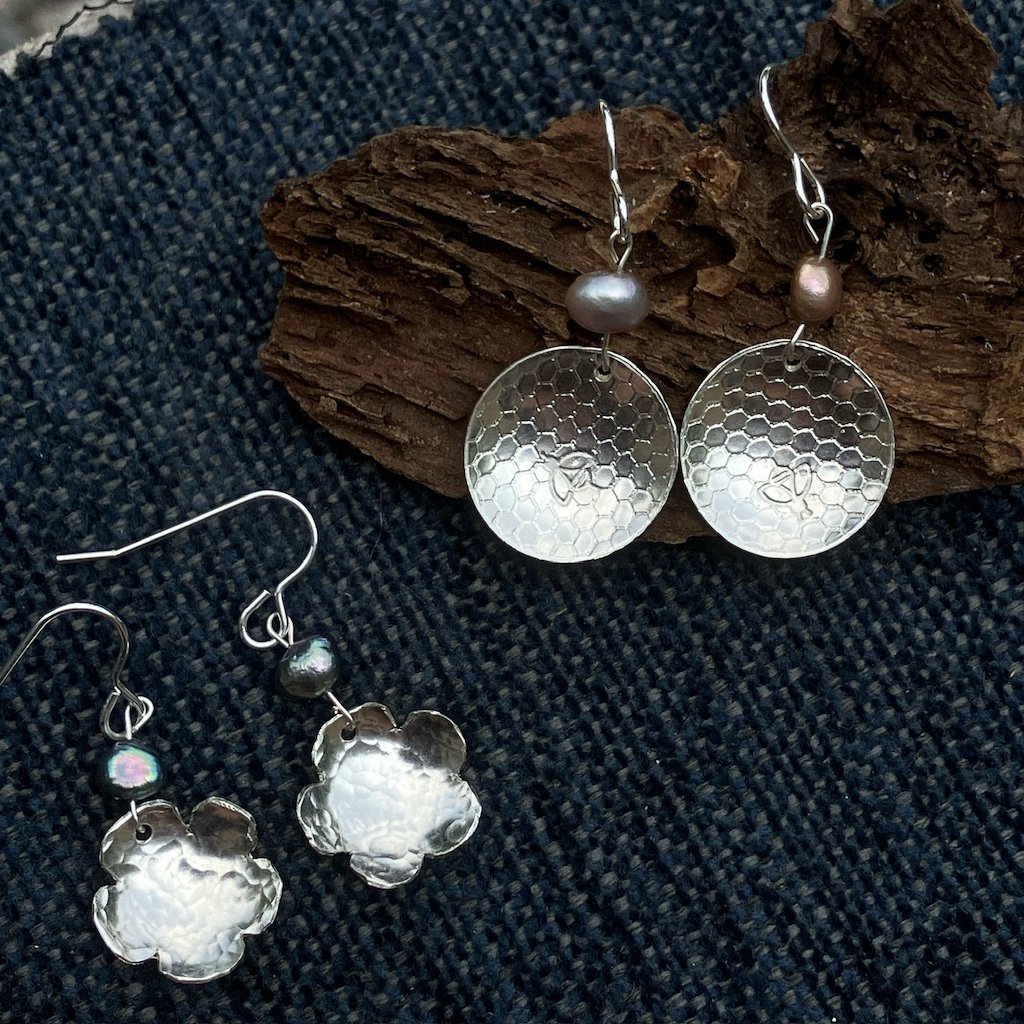 Silver earrings with pearls on a dark blue background