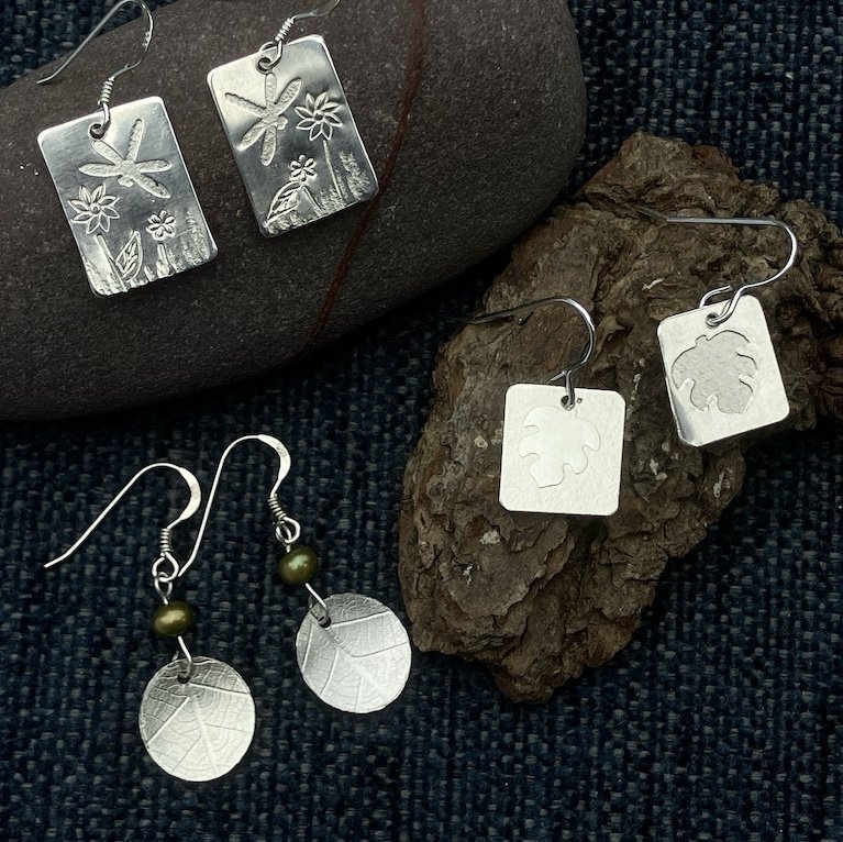 Three pairs of silver earrings with leaf printed surface and flower stamps