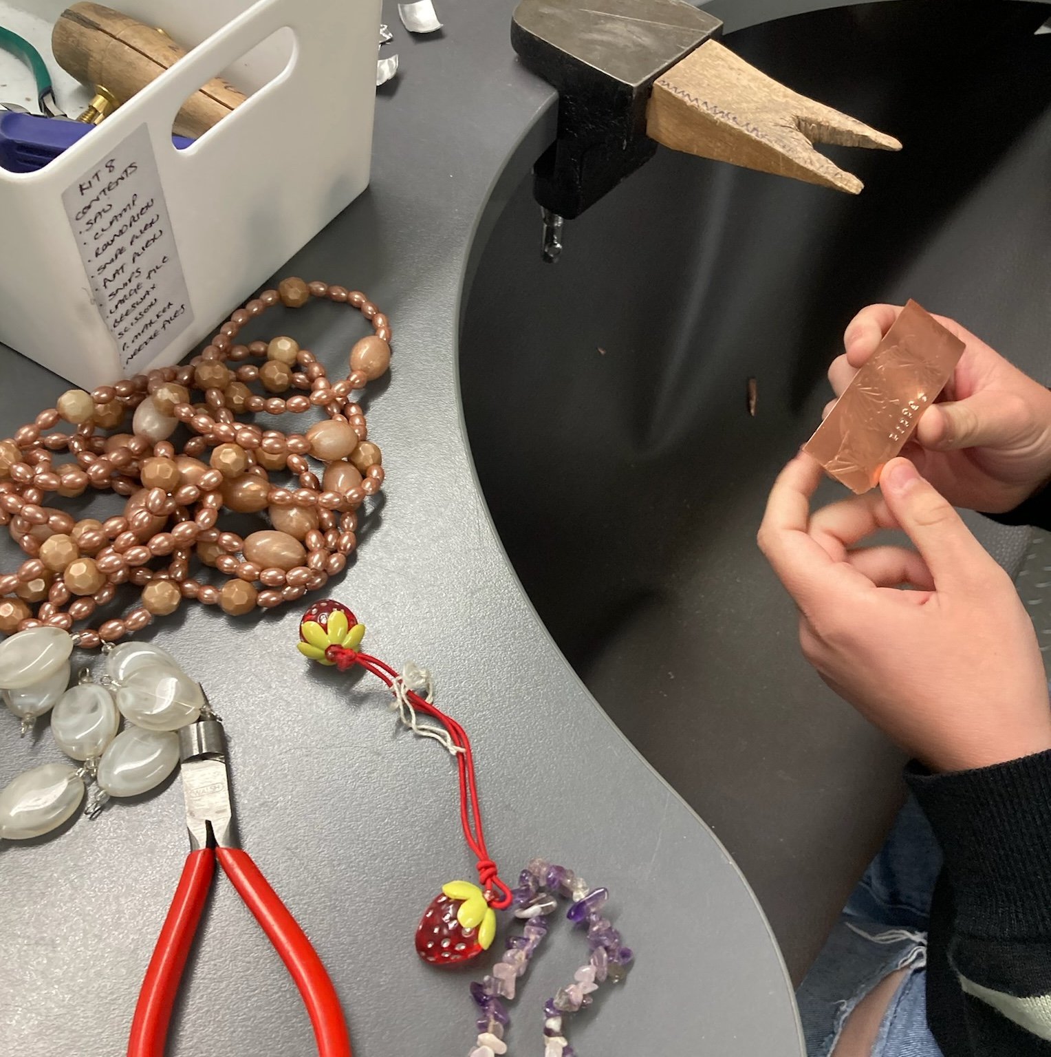 Broken jewellery and pliers on a jewellers bench