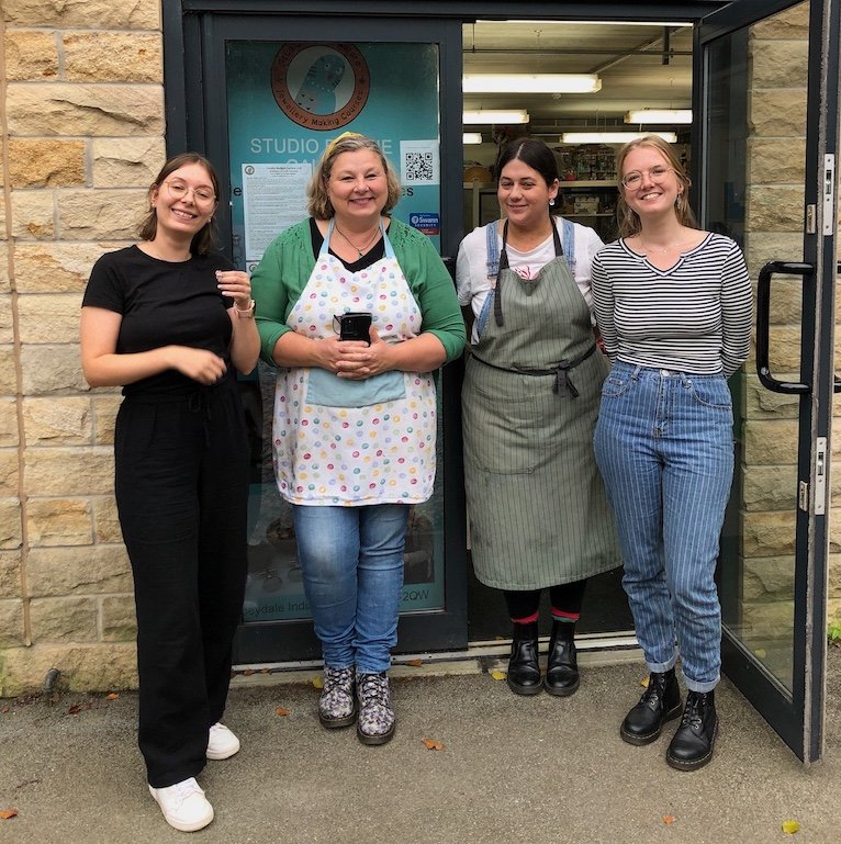 Happy smiling people outside the workshop wearing handmade earrings