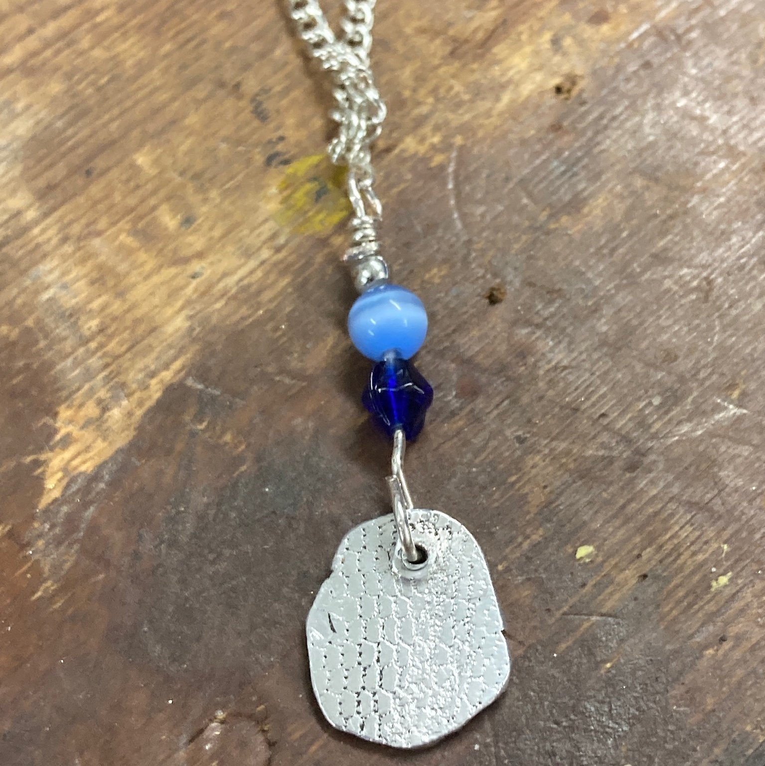 pendant with blue beads and textured metal