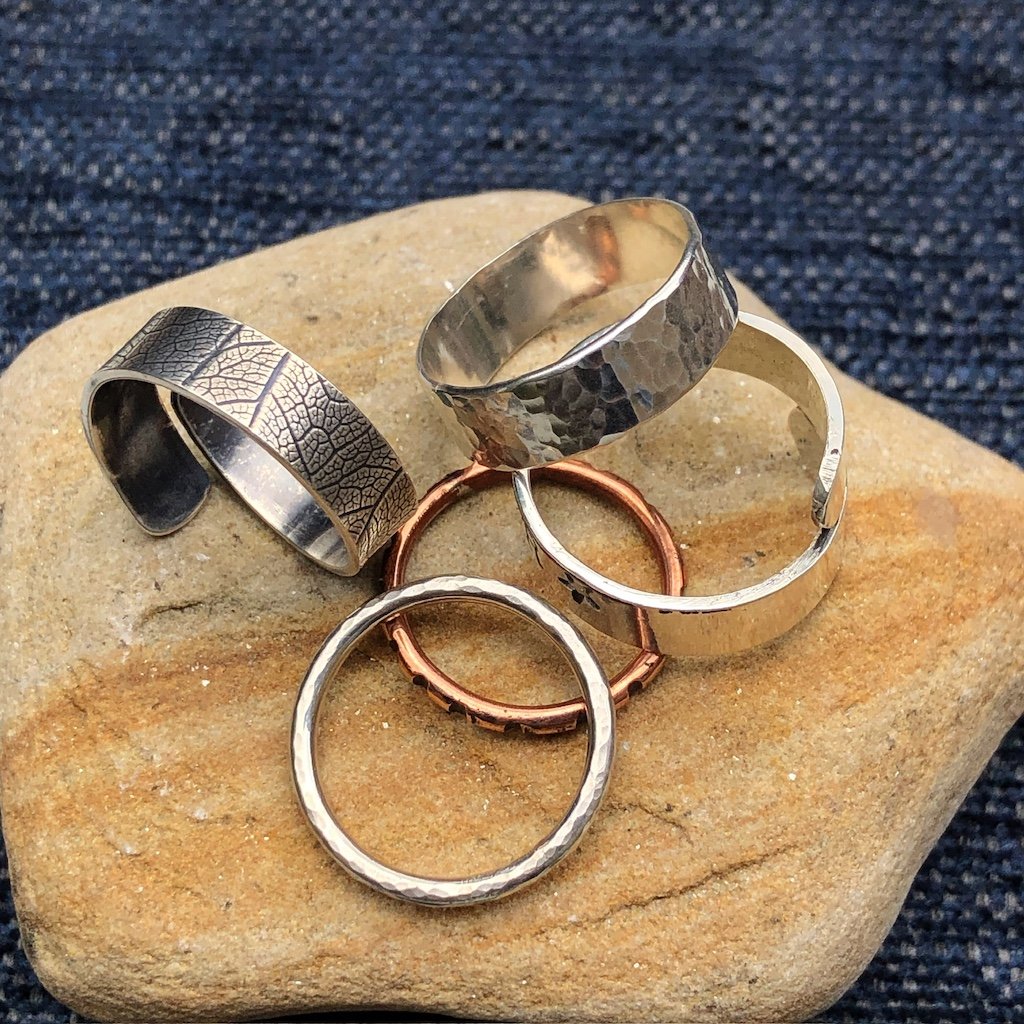 Silver and copper rings on a stone background